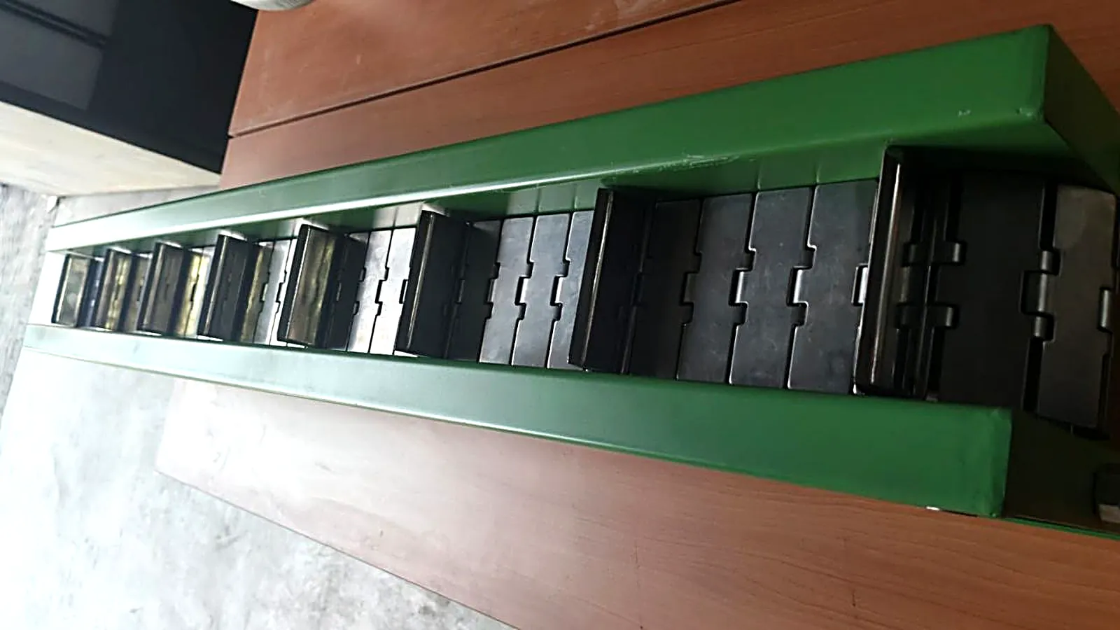 Rantai table top chain dengan bucket buatan MK di rangka plat besi hijau, untuk PT Insastama Kediri
